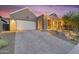 Front exterior featuring desert landscaping, modern architecture, and a spacious paver driveway at 1337 E Paseo Way, Phoenix, AZ 85042