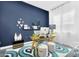 Modern home office with large window, glass desk, and stylish blue accent wall at 1337 E Paseo Way, Phoenix, AZ 85042