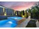 Backyard hot tub with a waterfall feature, surrounded by lush landscaping and ambient lighting for a serene and inviting retreat at 1337 E Paseo Way, Phoenix, AZ 85042