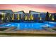Backyard pool with glowing cacti against a sunset sky, featuring custom stone tile, lighting, and a tranquil ambiance at 1337 E Paseo Way, Phoenix, AZ 85042