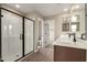Modern bathroom boasts dual sinks, sleek black hardware, and glass-enclosed shower with tile surround at 15599 S 180Th Ln, Goodyear, AZ 85338