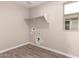 Laundry room features tile flooring, storage shelf, window, and washing machine hook-ups at 15599 S 180Th Ln, Goodyear, AZ 85338