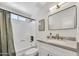 Clean bathroom with brushed brass fixtures, stylish vanity and tub and shower at 156 E Jasmine St, Mesa, AZ 85201