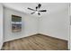 Bedroom with neutral walls, wood-look floors, and ceiling fan and bright natural light at 156 E Jasmine St, Mesa, AZ 85201