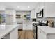 Bright, modern kitchen with white cabinets, stainless appliances and hardwood flooring at 156 E Jasmine St, Mesa, AZ 85201