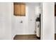 Bright laundry room features wood cabinets, utility sink hookups, and water filtration system at 156 E Jasmine St, Mesa, AZ 85201
