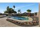 This backyard features a swimming pool surrounded by rocks and palm trees at 156 E Jasmine St, Mesa, AZ 85201