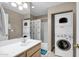 Well-lit bathroom with a vanity, mirror, and a stacked washer and dryer unit at 16357 E Arrow Dr # 115, Fountain Hills, AZ 85268