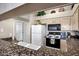 Open kitchen view with granite countertops, white cabinets, and a full suite of appliances at 16357 E Arrow Dr # 115, Fountain Hills, AZ 85268