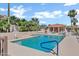 Inviting community pool surrounded by palm trees, lounge chairs, and clear blue skies at 16357 E Arrow Dr # 115, Fountain Hills, AZ 85268