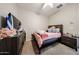 This cozy bedroom features a full sized bed, a ceiling fan, and carpeted floors at 16930 W Woodlands Ave, Goodyear, AZ 85338