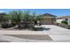 Charming single-story home featuring desert landscaping, a two-car garage, and a welcoming walkway at 16930 W Woodlands Ave, Goodyear, AZ 85338