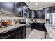 Kitchen featuring granite countertops, dark cabinets, and stainless steel appliances at 16930 W Woodlands Ave, Goodyear, AZ 85338