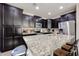 Spacious kitchen features granite countertops, stainless steel appliances, and dark wood cabinets at 16930 W Woodlands Ave, Goodyear, AZ 85338