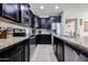 Kitchen featuring granite countertops, stainless steel appliances, and dark wood cabinetry at 16930 W Woodlands Ave, Goodyear, AZ 85338