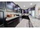 Kitchen featuring dark wood cabinets, stainless steel appliances, and granite countertops at 16930 W Woodlands Ave, Goodyear, AZ 85338