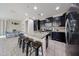 Open kitchen with granite countertops, dark cabinets, and stainless steel appliances at 16930 W Woodlands Ave, Goodyear, AZ 85338