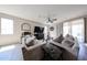 Bright living room featuring tile floors, comfortable seating, and a large sliding glass door at 16930 W Woodlands Ave, Goodyear, AZ 85338