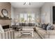 Cozy living room with a stone fireplace, neutral-toned sofas, and large windows providing natural light at 1884 E Stephens Dr, Tempe, AZ 85283