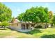 Spacious backyard with mature trees providing shade, a patio, and ample space for outdoor activities at 19030 N Signal Butte Cir, Sun City, AZ 85373