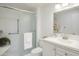 Bright bathroom with a glass-enclosed shower, grab bars, and a modern vanity with fresh flowers at 19030 N Signal Butte Cir, Sun City, AZ 85373