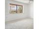 Bright, carpeted room featuring a large window and shutters at 19030 N Signal Butte Cir, Sun City, AZ 85373