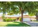 Charming home with a well-manicured lawn, mature trees, and a covered front entrance at 19030 N Signal Butte Cir, Sun City, AZ 85373