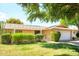 Charming single story home featuring a pergola, desert landscaping, and a well-manicured lawn at 19030 N Signal Butte Cir, Sun City, AZ 85373