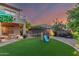 A sprawling green lawn, playground, and trampoline providing endless outdoor fun in the backyard at 194 E Canyon Creek Dr, Gilbert, AZ 85295
