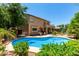 Beautiful backyard featuring a private pool, lush landscaping, and a spacious covered patio at 194 E Canyon Creek Dr, Gilbert, AZ 85295