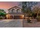 Charming two-story home featuring a three-car garage, well-maintained landscaping, and warm exterior lighting at 194 E Canyon Creek Dr, Gilbert, AZ 85295