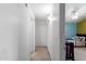 Bright hallway featuring neutral carpet, white walls, doors and access to a bedroom with ceiling fan at 194 E Canyon Creek Dr, Gilbert, AZ 85295