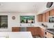 Bright kitchen featuring white countertops, wood cabinets, and a view to the green landscape through window at 194 E Canyon Creek Dr, Gilbert, AZ 85295