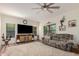Spacious living room features a ceiling fan, large TV, neutral paint, and wood-look floors at 194 E Canyon Creek Dr, Gilbert, AZ 85295