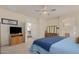 A primary bedroom with a ceiling fan, entertainment center, dresser, and view of the attached ensuite bath at 194 E Canyon Creek Dr, Gilbert, AZ 85295