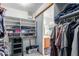A functional walk-in closet featuring shelving units and clothing racks, with a glimpse into the adjacent bathroom at 194 E Canyon Creek Dr, Gilbert, AZ 85295