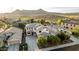 Aerial view of a residence showcases a long driveway, desert landscaping, solar panels and desert backdrop at 2556 E Quiet Hollow Ln, Phoenix, AZ 85024