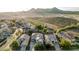 Aerial view of a residence showcases a long driveway, desert landscaping, solar panels and desert backdrop at 2556 E Quiet Hollow Ln, Phoenix, AZ 85024