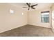 A neutral bedroom includes a ceiling fan, three windows, and neutral walls with carpeting at 2556 E Quiet Hollow Ln, Phoenix, AZ 85024