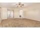 Large carpeted bedroom with ceiling fan and view into the en suite bathroom and adjacent hallway at 2556 E Quiet Hollow Ln, Phoenix, AZ 85024