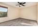 A beige bedroom includes a ceiling fan, a window with blinds, neutral colored walls, and tan carpeting at 2556 E Quiet Hollow Ln, Phoenix, AZ 85024