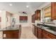 Open-concept kitchen and breakfast nook with wood cabinets, granite countertops, and tile floors at 2556 E Quiet Hollow Ln, Phoenix, AZ 85024