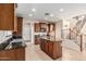 Traditional-style kitchen with wood cabinets, granite countertops, stainless steel appliances, and adjacent staircase at 2556 E Quiet Hollow Ln, Phoenix, AZ 85024