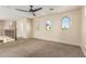 Carpeted loft area with arched windows and a ceiling fan at 2556 E Quiet Hollow Ln, Phoenix, AZ 85024