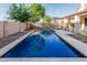 Backyard pool surrounded by gravel, patio, and a block wall, perfect for relaxation and entertaining at 2556 E Quiet Hollow Ln, Phoenix, AZ 85024