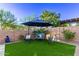Cozy backyard seating area with a patio umbrella, offering a peaceful space for relaxation and outdoor enjoyment at 2618 E Stacey Rd, Gilbert, AZ 85298