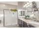 Bathroom with double sinks, granite counters, large mirrors, and a frameless glass shower at 2618 E Stacey Rd, Gilbert, AZ 85298