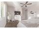 Cozy bedroom with neutral walls, carpet, ceiling fan, a large TV and floor-length mirror at 2618 E Stacey Rd, Gilbert, AZ 85298