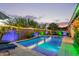 Backyard pool area featuring ambient lighting, a serene waterfall, and lush landscaping for a relaxing outdoor experience at 2618 E Stacey Rd, Gilbert, AZ 85298