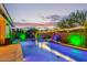 Backyard featuring a pool with a gentle waterfall, surrounded by lush landscaping, providing a tranquil and inviting atmosphere at 2618 E Stacey Rd, Gilbert, AZ 85298